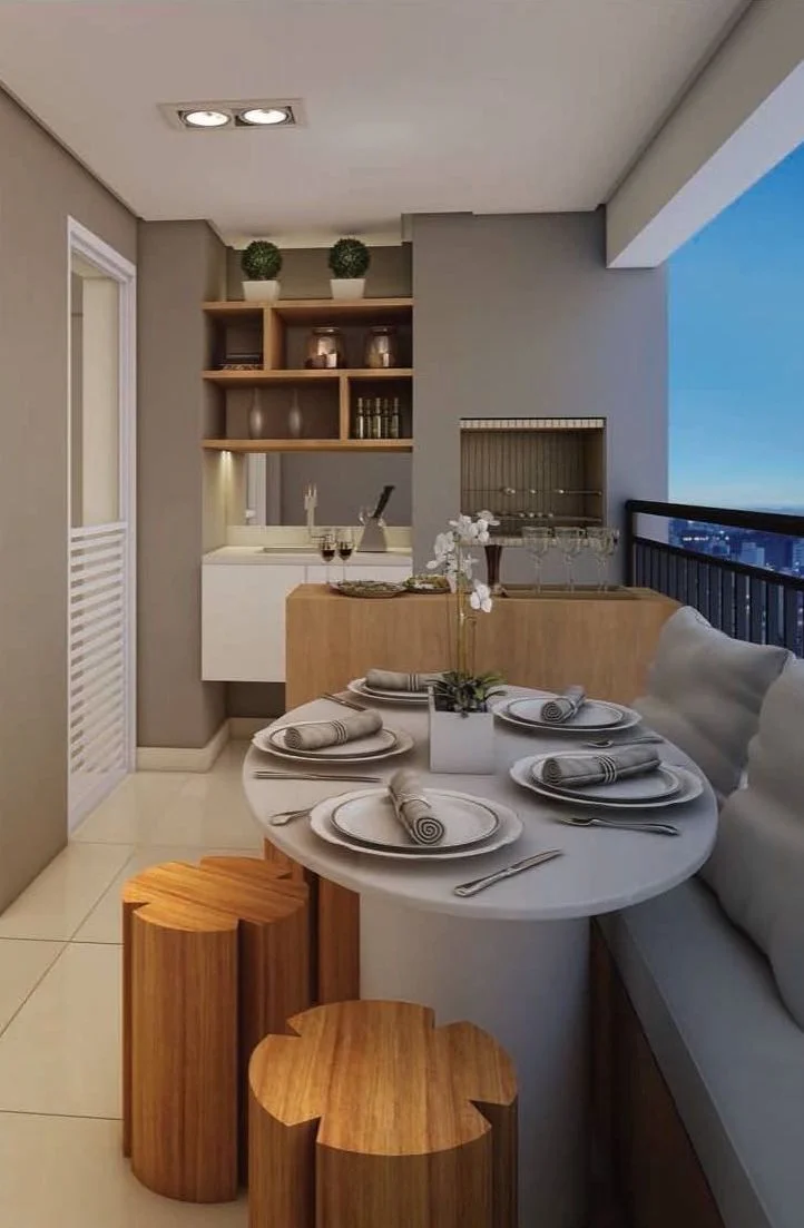 Varanda gourmet de apartamento com churrasqueira elétrica, bancada pequena e um jardim vertical.