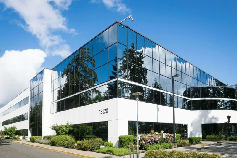 Edificio corporativo com fachada espelhada de vidro e estrutura modular — arquitetura corporativa premium