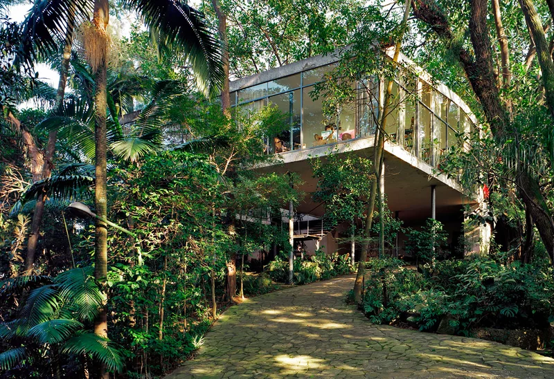 Casa de Vidro de Lina Bo Bardi de 1951 no Morumbi com estrutura de aço, pilotis e fechamento de vidro envolvida pela mata atlântica