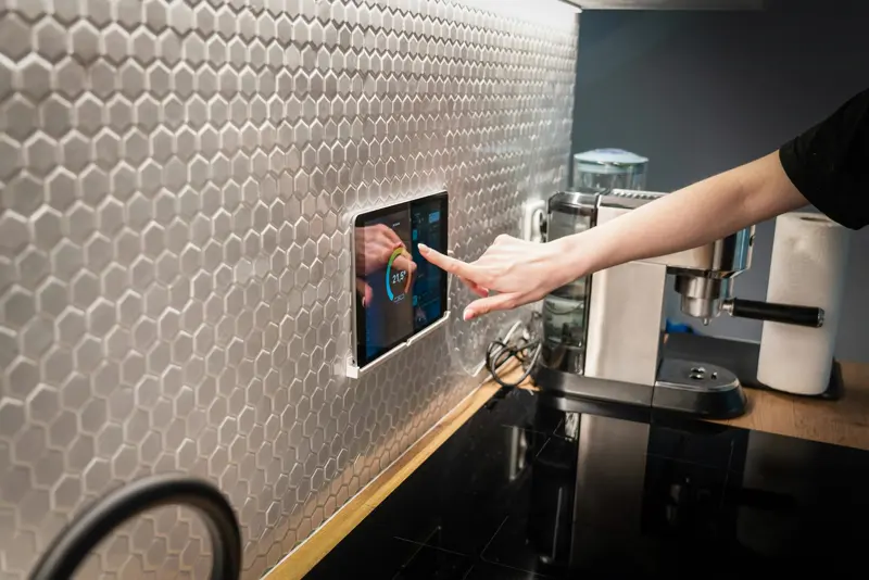 Painel touchscreen de automação residencial integrado à parede de cozinha moderna — controle de casa inteligente
