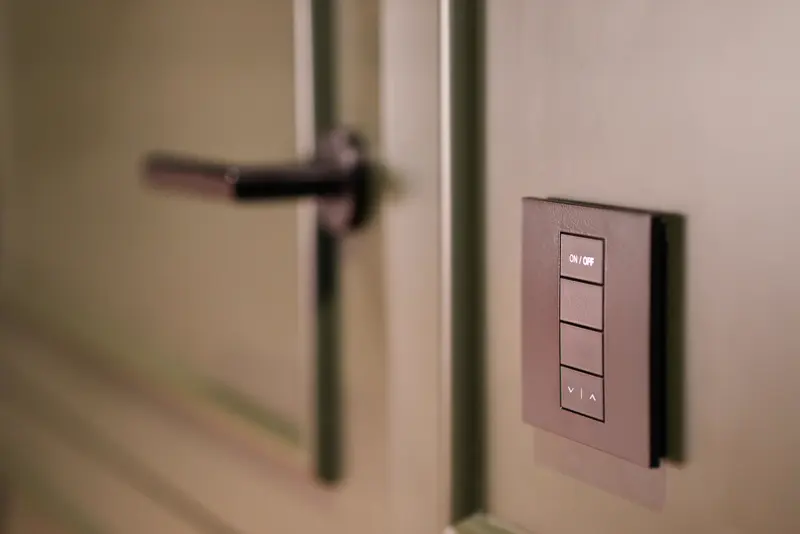 Interruptor inteligente embutido na parede ao lado de maçaneta moderna — automação residencial integrada ao projeto