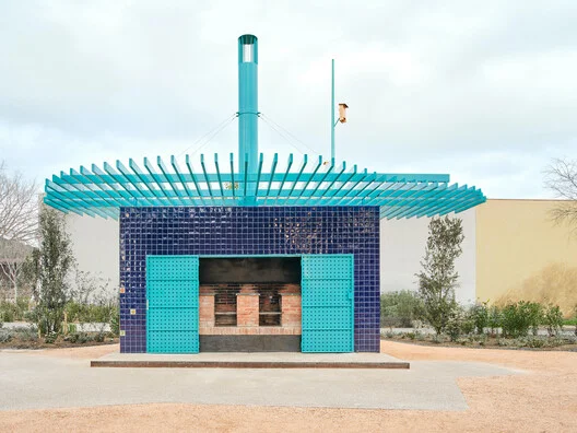 Churrasqueira de alvenaria com chaminé alta cilíndrica em área externa, exemplo de tiragem dimensionada