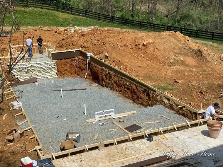 Construção real de piscina em alvenaria mostrando armação, lastro e dreno perimetral antes do revestimento