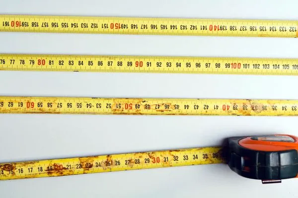 Trenas e fitas métricas com diferentes escalas dispostas sobre uma superfície