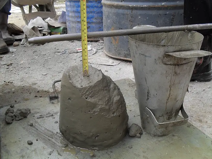 Trena metálica medindo o abatimento de um cone de concreto em obra (slump test)