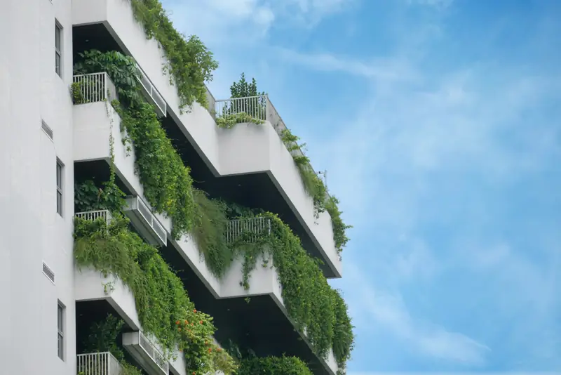 Fachada de edifício sustentável com jardim vertical e aberturas amplas para ventilação natural