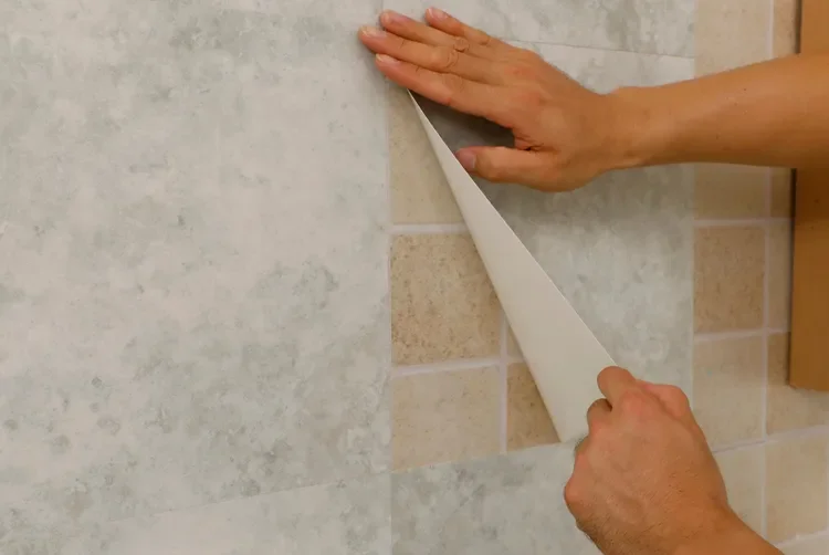 Aplicação de pastilhas adesivas resinadas sobre os azulejos antigos de uma cozinha.