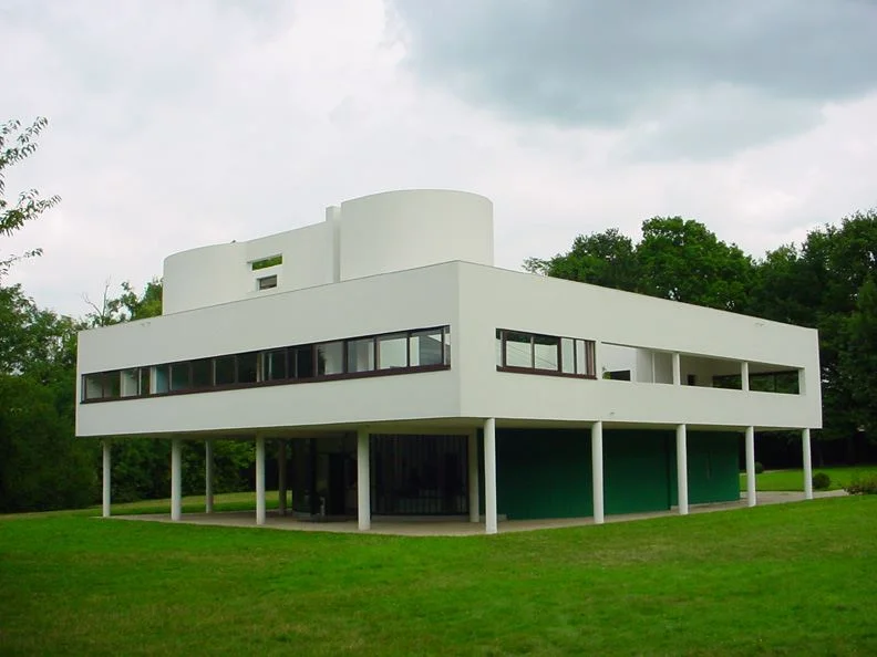 Villa Savoye de Le Corbusier em Poissy: volume branco retangular com janela em fita suspenso sobre uma fileira de pilares cilíndricos finos, com o térreo recuado e aberto sob a laje