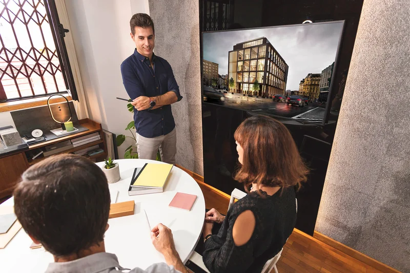 Arquiteto apresentando um projeto de casa para um casal de clientes.