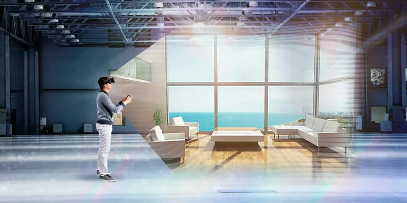 Pessoa com headset de realidade virtual explorando interior de apartamento amplo com sofás e vista para o mar