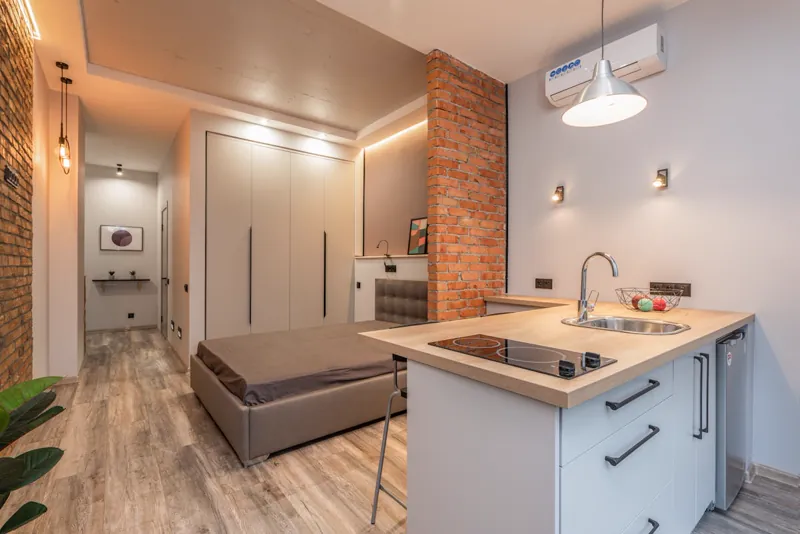Studio com cozinha e dormitório integrados em espaço multifuncional de planta aberta